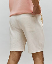 Mens Maxton Waffle Sweatshort in cream, featuring a comfortable, relaxed fit, soft waffle knit fabric, and a single back patch pocket with side pockets.