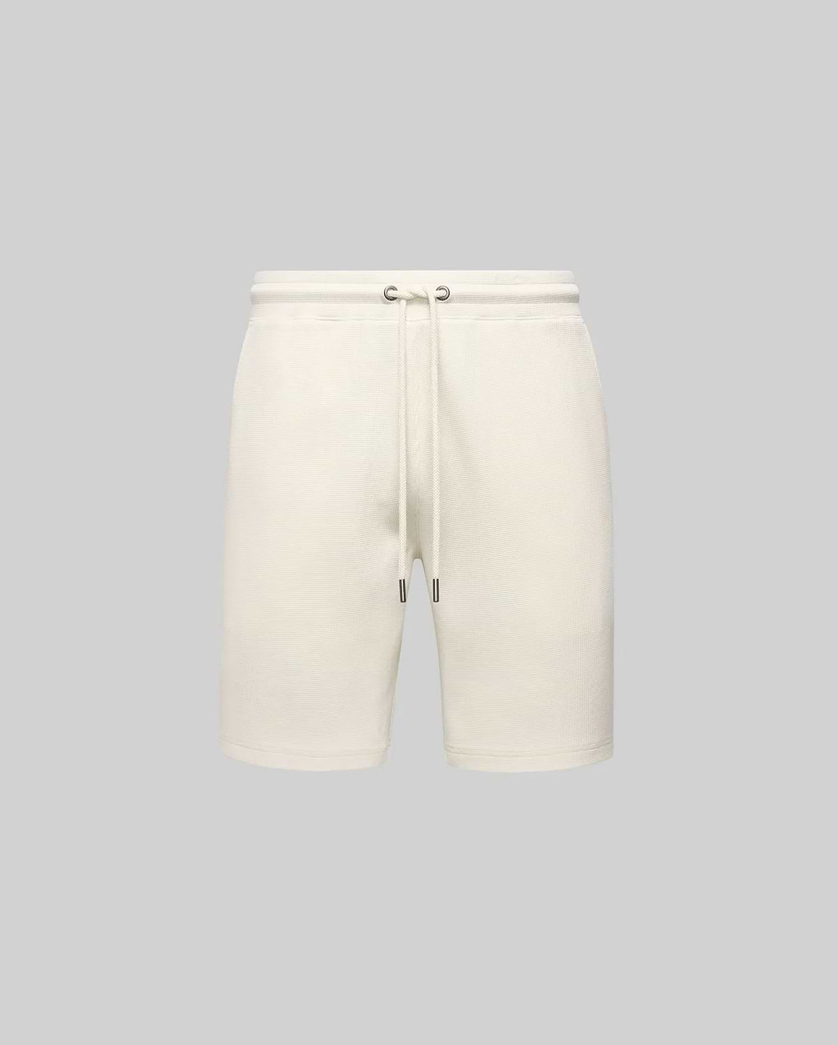 Mens Maxton Waffle Sweatshort in cream, a relaxed fit garment with a soft waffle knit texture, featuring a drawstring waist with dark metal tips. No visible Psycho Bunny logo.