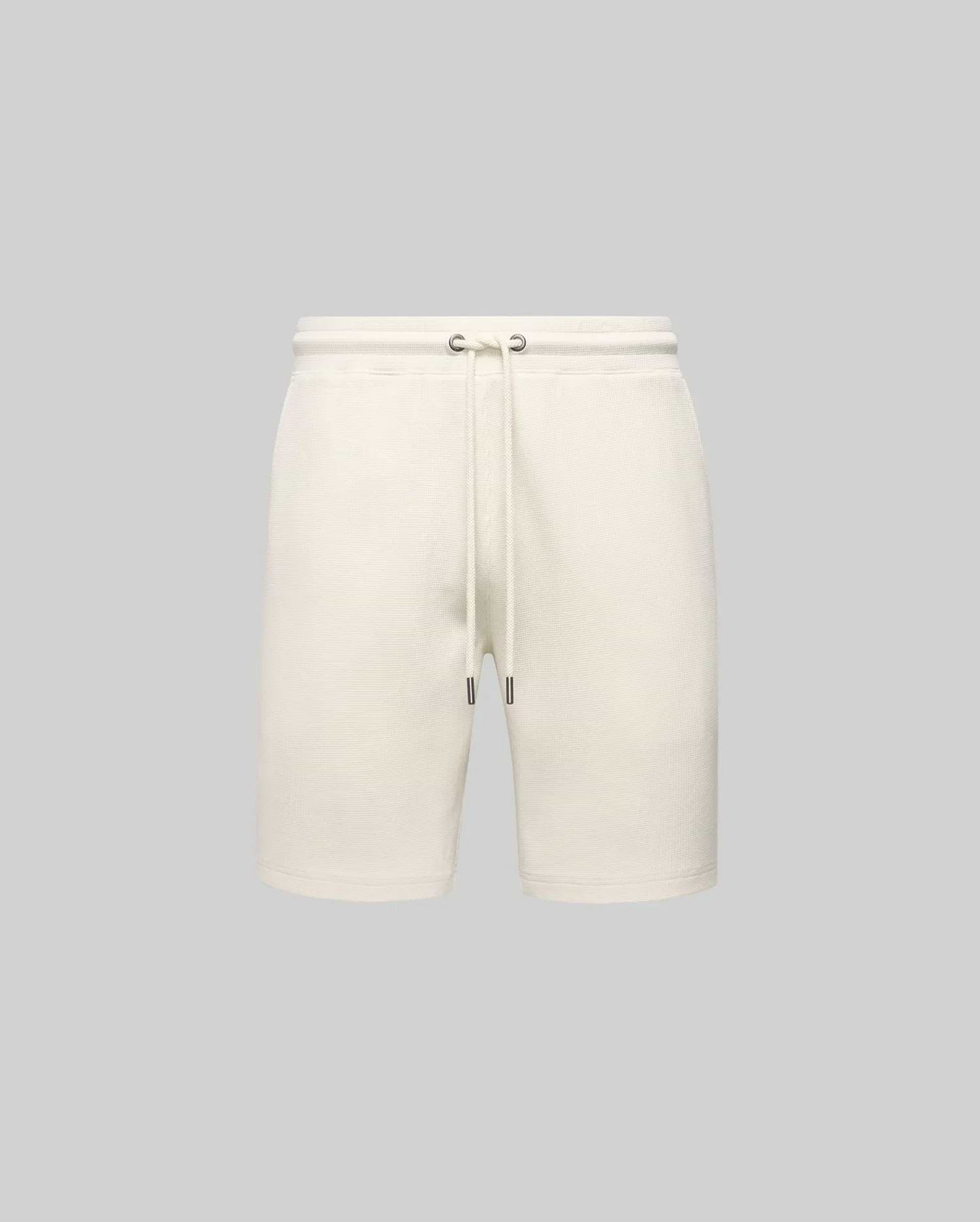 Mens Maxton Waffle Sweatshort in cream, a relaxed fit garment with a soft waffle knit texture, featuring a drawstring waist with dark metal tips. No visible Psycho Bunny logo.