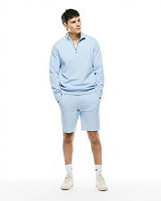 Light blue textured knit quarter-zip sweatshirt and matching Mens Marc Textured Short set. Features a silver zipper, black drawstring, and small embroidered Psycho Bunny skull logo.