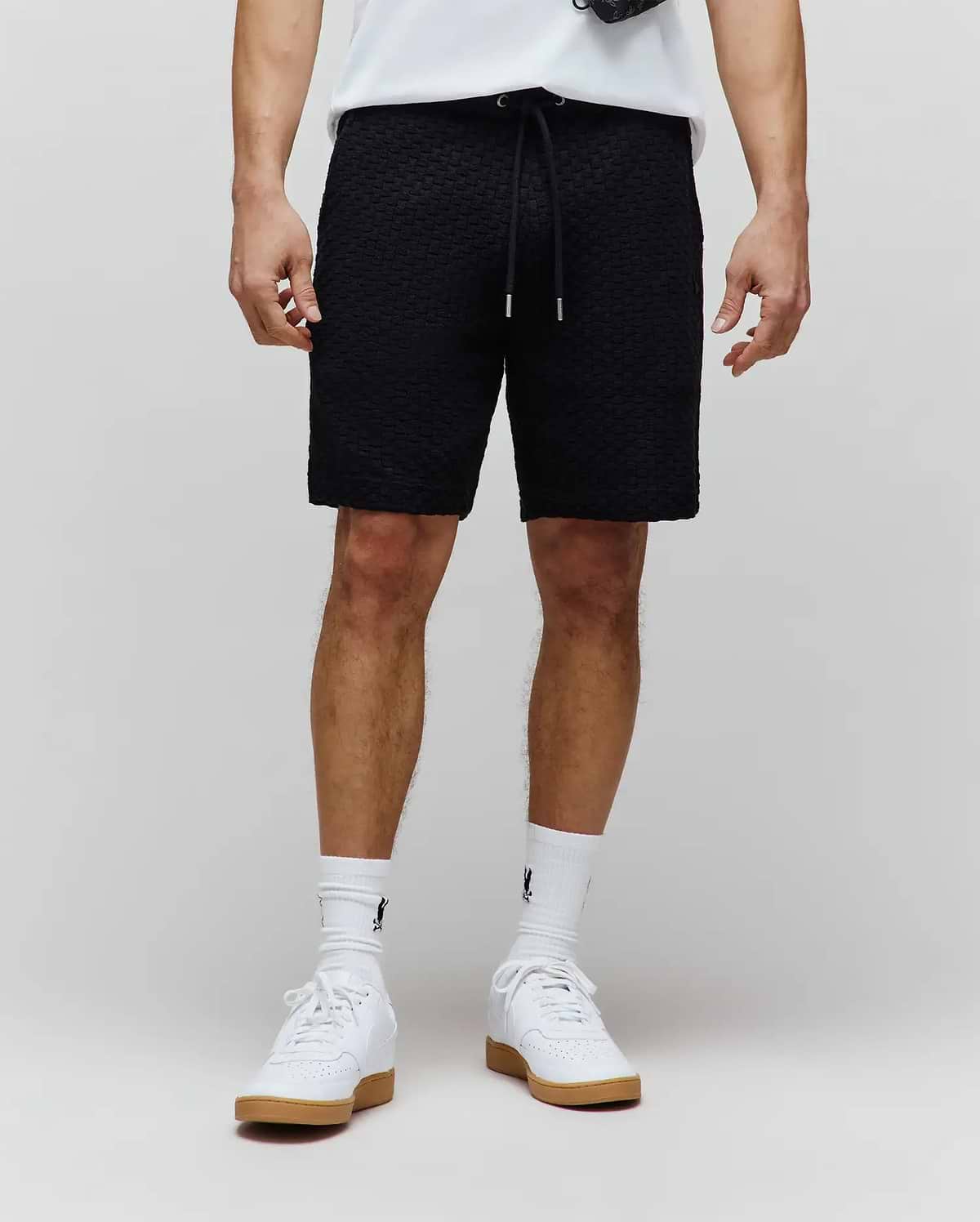 Mens Garen Knit Short, black textured knit with a relaxed fit, featuring a drawstring waist with silver tips and a subtle tonal embroidered Psycho Bunny logo on the left thigh. (1)