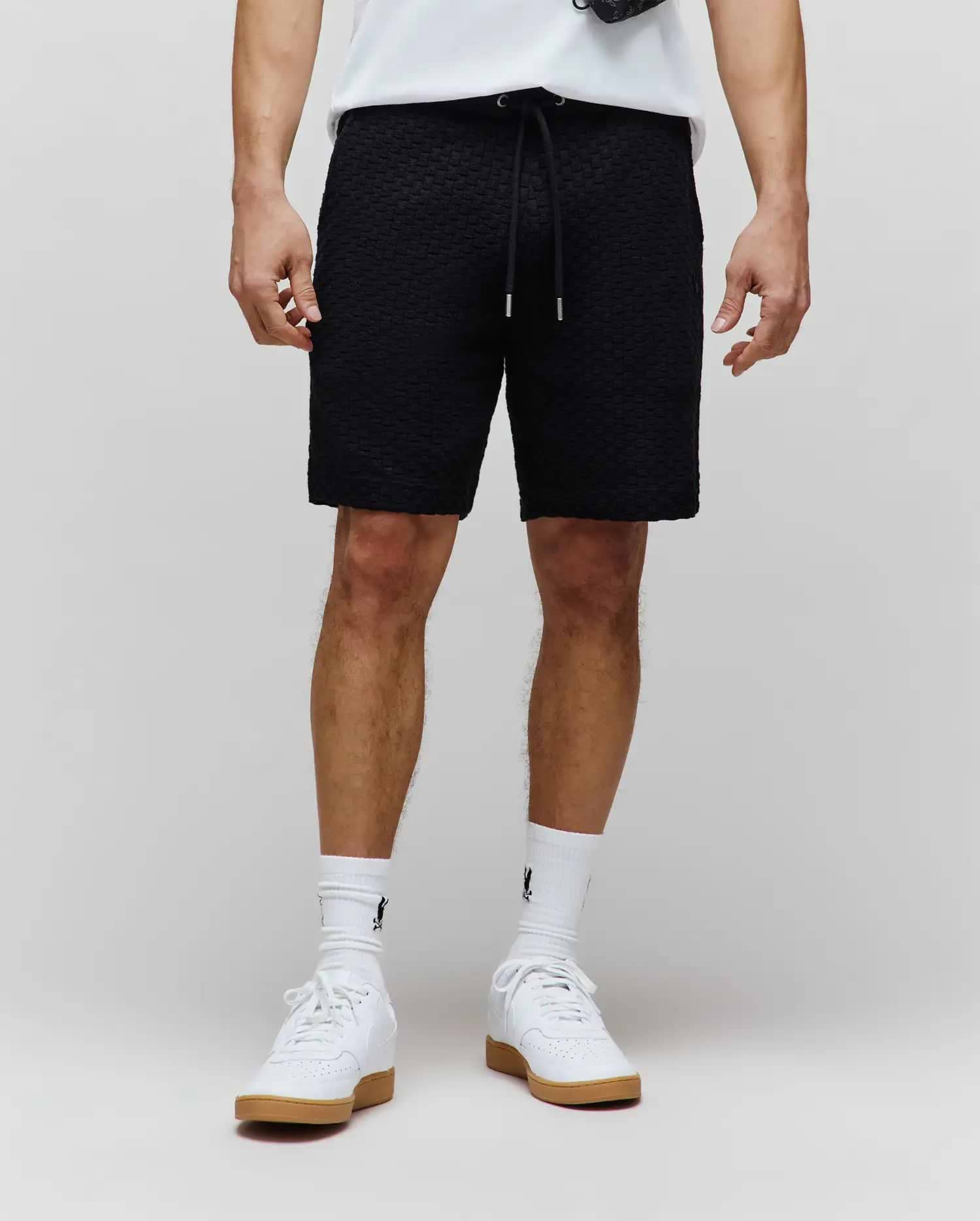 Mens Garen Knit Short, black textured knit with a relaxed fit, featuring a drawstring waist with silver tips and a subtle tonal embroidered Psycho Bunny logo on the left thigh. (1)
