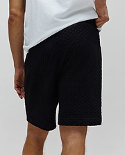 Black Mens Garen Knit Short, a relaxed fit premium streetwear piece featuring a unique, all-over textured knit fabric with a subtle geometric pattern, embodying Psycho Bunny's bold style. (3)
