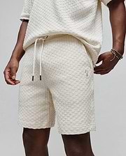 Mens Garen Knit Short in ecru, a relaxed fit short with a textured checkered knit, drawstring waist featuring dark tips, and a small embroidered Psycho Bunny skull logo on the left thigh. (2)
