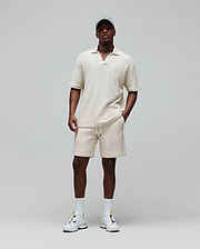 Cream textured knit polo and Mens Garen Knit Short set, both relaxed fit with small embroidered Psycho Bunny skull logos, polo on chest, shorts on left leg, shorts also have drawstring waist. (3)