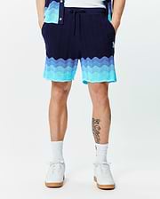 Mens Holden Knit Short 6, a premium navy blue wavy knit short with a vibrant ombre transition to light blue and turquoise, featuring a small embroidered Psycho Bunny skull logo.