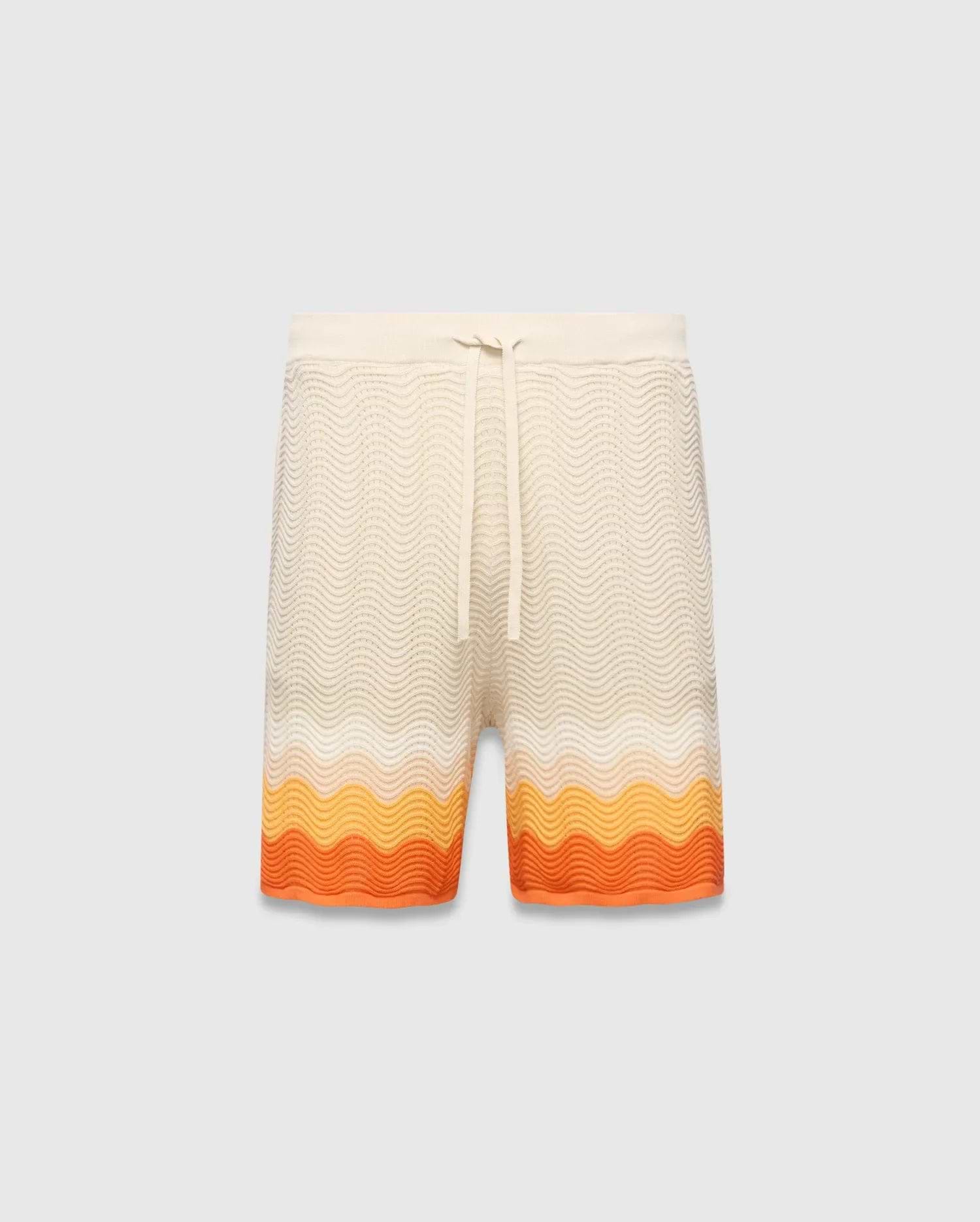 Mens Holden Knit Short 6, a cream relaxed fit knit short with a wavy texture and a bold orange and yellow gradient stripe pattern at the hem, featuring a drawstring waist.