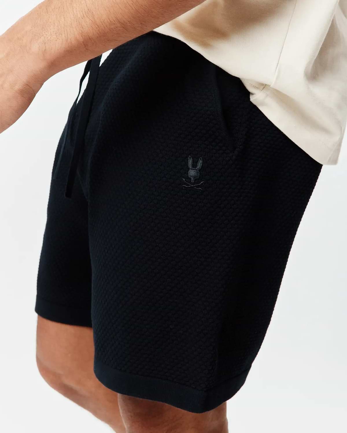 Psycho Bunny Black Mens Devon Knit Short, a relaxed fit with textured knit fabric, drawstring waist, and small tonal embroidered bunny skull logo on the left thigh.