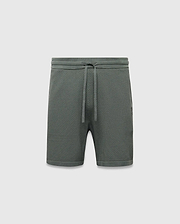 Mens Devon Knit Short 7, a relaxed fit dark green short featuring a textured pique knit fabric, drawstring waist, and a small tonal embroidered Psycho Bunny skull logo on the right leg.