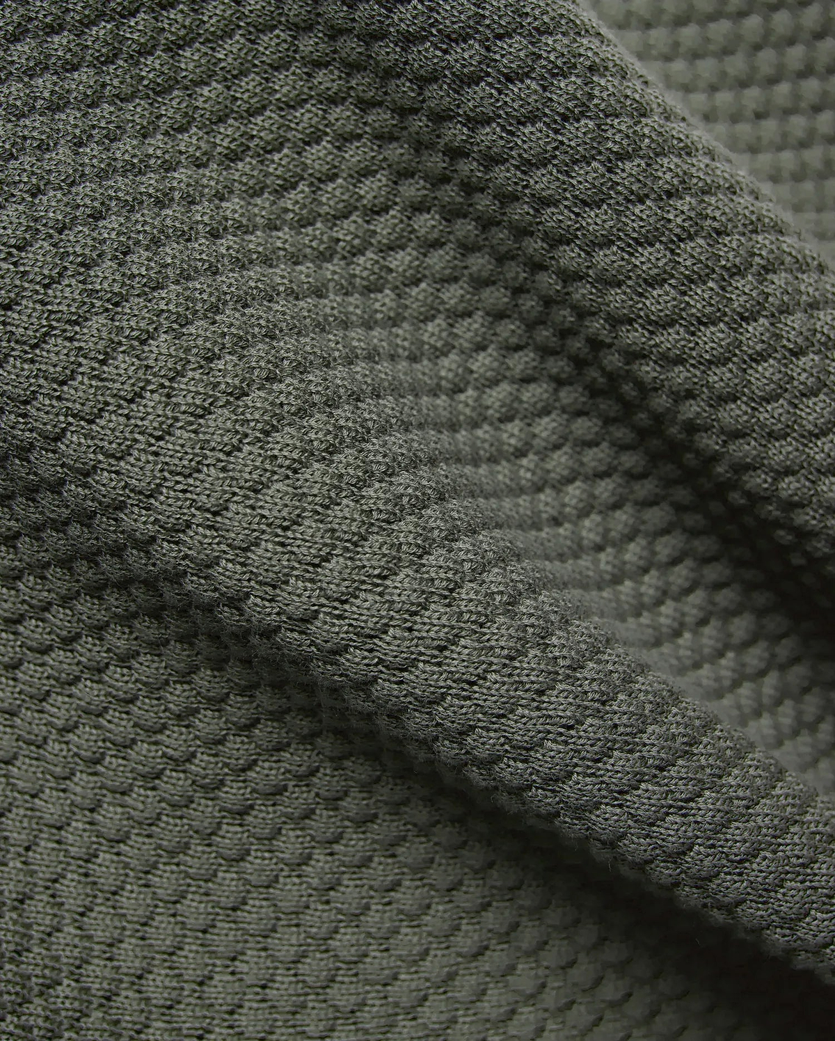 Mens Devon Knit Short 7, in deep olive green, crafted from a luxurious, soft, and breathable textured knit fabric with a distinctive raised, dimpled pattern.