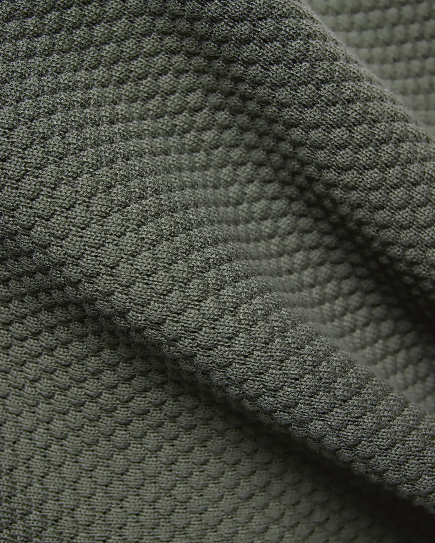 Mens Devon Knit Short 7, in deep olive green, crafted from a luxurious, soft, and breathable textured knit fabric with a distinctive raised, dimpled pattern.
