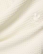 Mens Devon Knit Short in premium cream, featuring a soft, subtly patterned open knit fabric and a small, tone-on-tone embroidered Psycho Bunny skull logo detail.