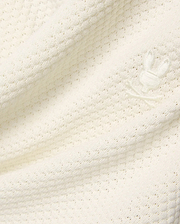 Mens Devon Knit Short in premium cream, featuring a soft, subtly patterned open knit fabric and a small, tone-on-tone embroidered Psycho Bunny skull logo detail.