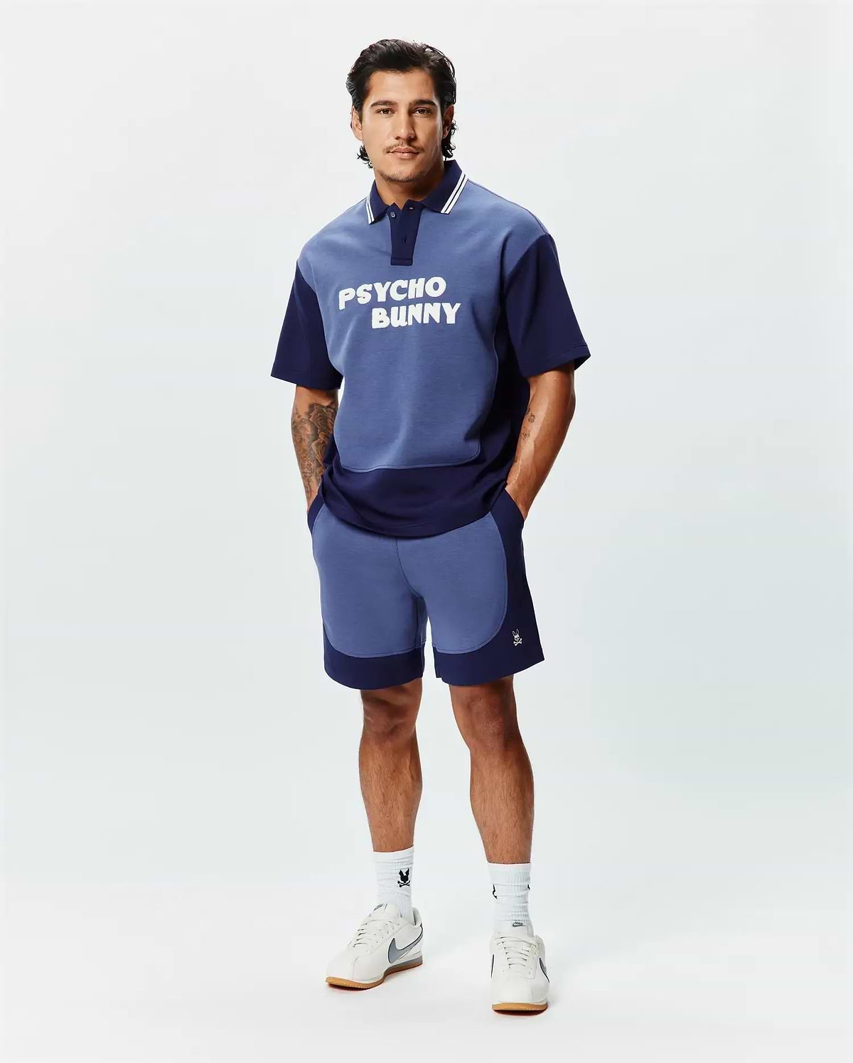 Relaxed fit two-tone blue jersey polo with large white PSYCHO BUNNY chest graphic, striped collar, and matching color-blocked Mens Kelly Short featuring a small embroidered skull logo. (4)