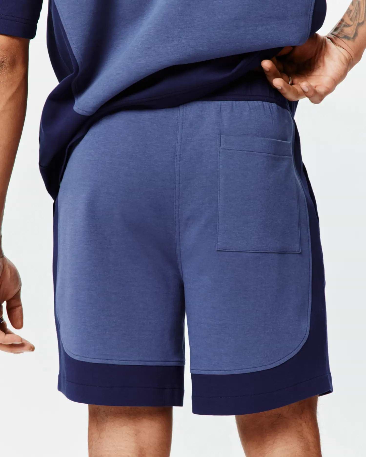 Mens Kelly Short: Relaxed fit heather blue jersey shorts featuring dark navy color-block side panels, an elastic waistband, and a single back patch pocket. (3)