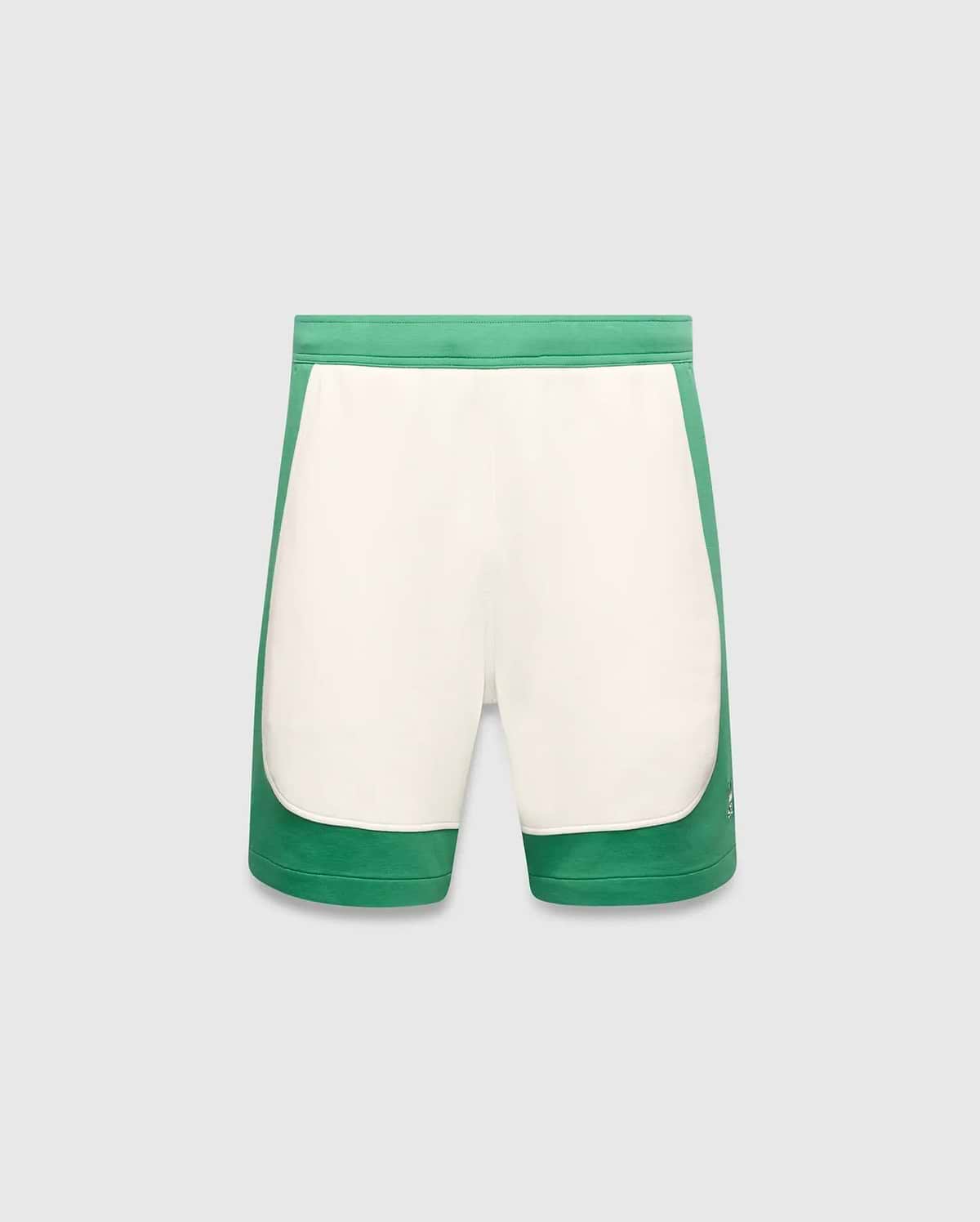 Mens Kelly Short, a color-blocked design with vibrant green outer panels and a cream central panel, featuring a small embroidered Psycho Bunny skull logo on the lower left leg. Smooth knit fabric, classic fit. (5)