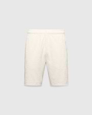 Mens Tristan Short in cream, a relaxed fit short with an all-over raised geometric concentric square pattern on textured fabric, no visible Psycho Bunny logo.