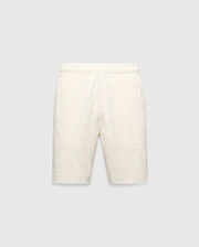 Mens Tristan Short in cream, a relaxed fit short with an all-over raised geometric concentric square pattern on textured fabric, no visible Psycho Bunny logo.