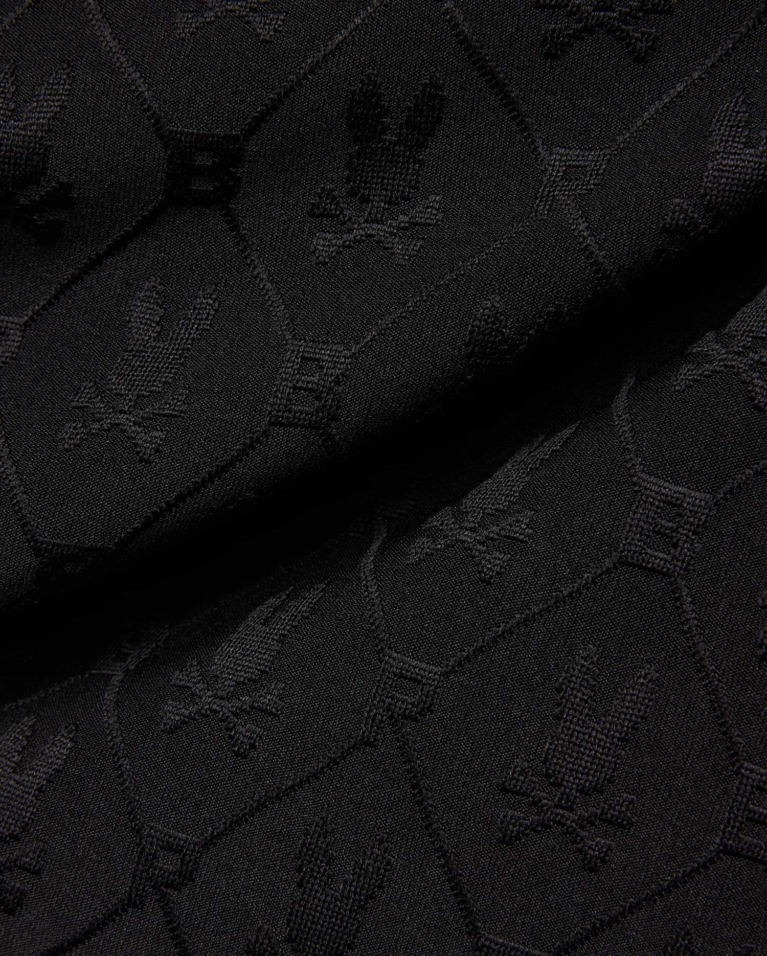 Mens Garry Jacquard Sweatshort in black, featuring a tonal all-over jacquard knit pattern of the iconic Psycho Bunny skull logo and PB initials.