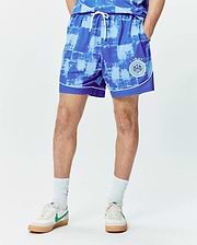 Micah Soccer Short 6 3/4, blue and light blue distressed checkered pattern, smooth fabric, white drawstring and piping, with a Psycho Bunny Football Club patch and 3 stars on the lower right leg. (1)
