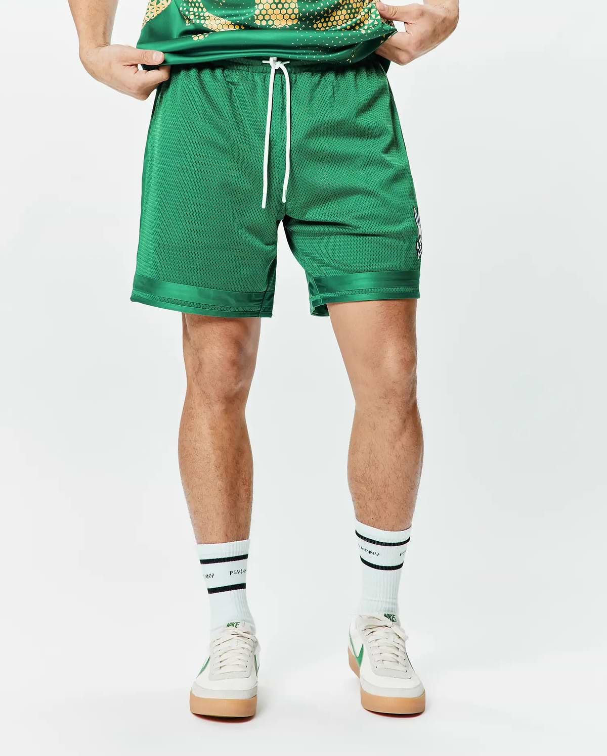 Mens Joshua Soccer Short 7 1/4, a relaxed fit vibrant green mesh short with white drawstrings, satin-like hem trim, and a small embroidered Psycho Bunny skull logo on the left leg. (3)