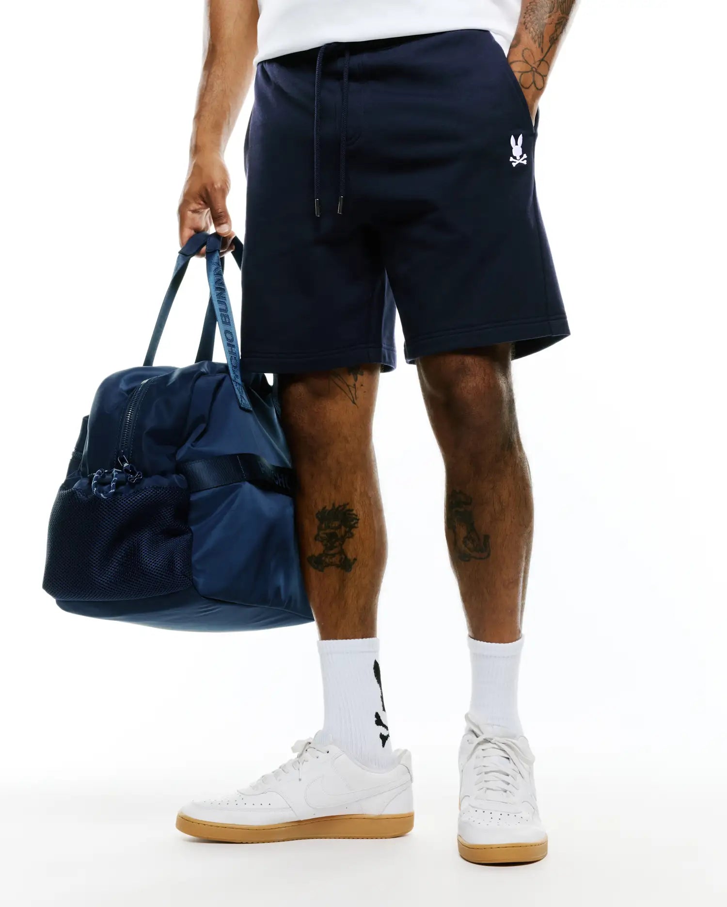 Mens Gabe French Terry Sweatshort in navy blue, featuring a relaxed fit, drawstring waist with silver tips, and a small embroidered white Psycho Bunny skull logo on the left thigh. (3)