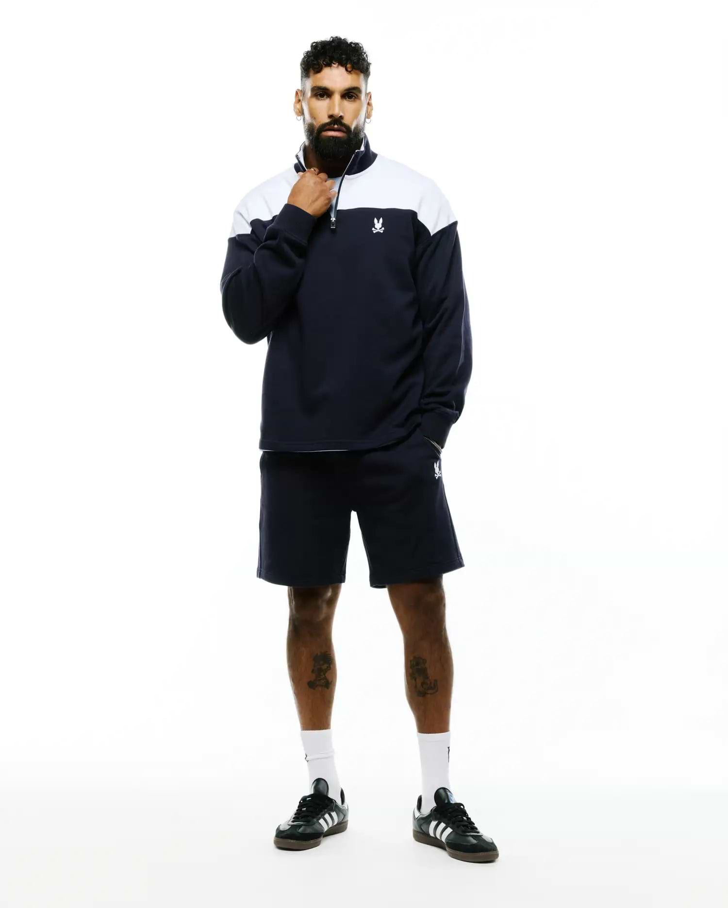 Navy French terry quarter-zip sweatshirt with white color block and embroidered Psycho Bunny skull logo, paired with matching Mens Gabe French Terry Sweatshort featuring an embroidered bunny skull. (1)