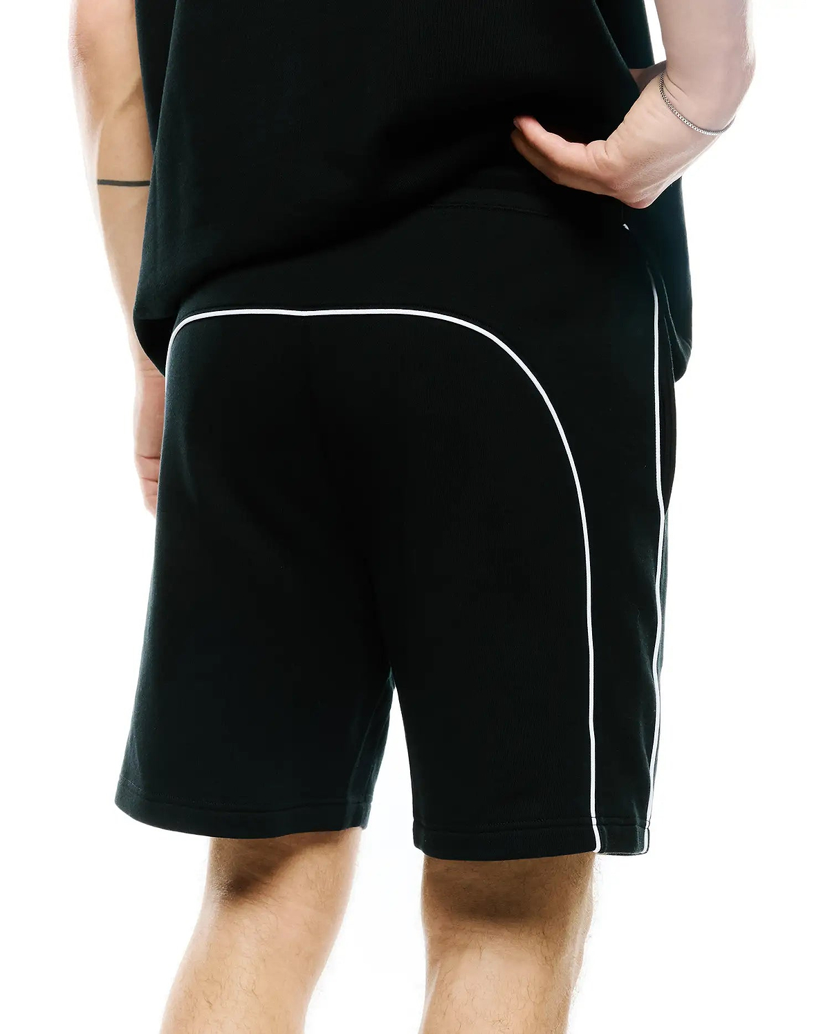 Mens Stevie Short, black relaxed fit jersey shorts featuring prominent white contrast piping that curves across the upper back and extends down the side seams, offering a refined streetwear aesthetic.