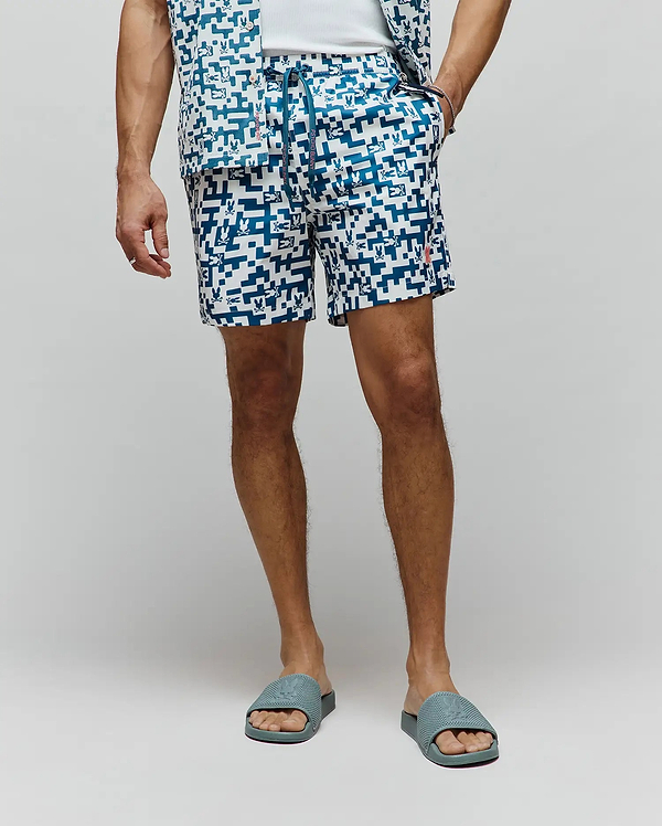 Mens Josh Swim Trunk in white with a teal pixelated geometric pattern featuring small Psycho Bunny skull logos, a branded drawstring, and a small embroidered red bunny logo on the left leg.