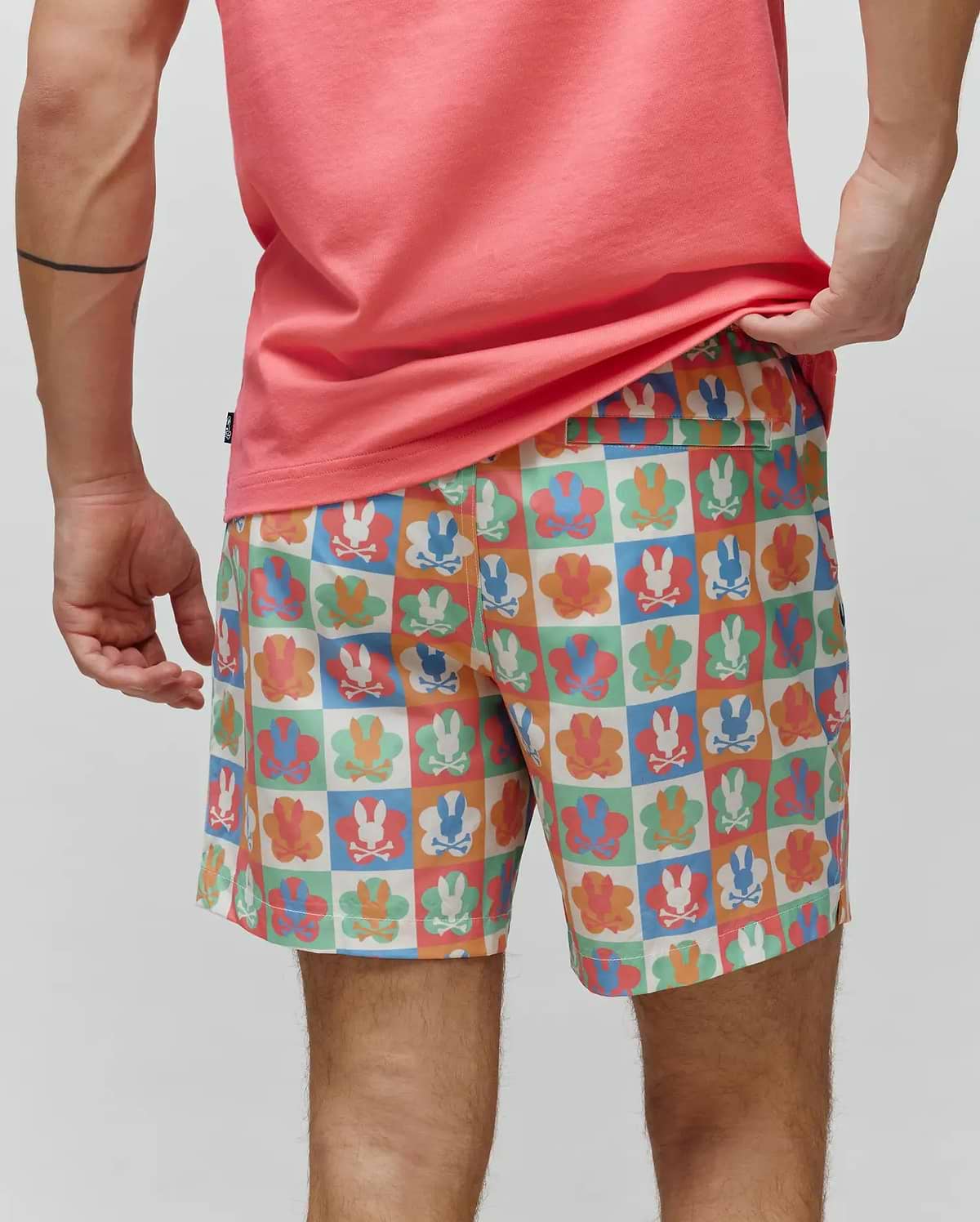 Mens Aiden Swim Trunk featuring a vibrant multicolor checkered pattern with alternating Psycho Bunny skull logos and floral graphics in blue, orange, green, and pink on a smooth, relaxed-fit fabric. (3)