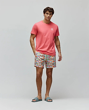 Coral pink classic fit jersey t-shirt with small white embroidered Psycho Bunny logo on left chest, paired with Mens Aiden Swim Trunk featuring a vibrant multi-color checkerboard pattern of Psycho Bunny skull logos and a drawstring waist. (4)