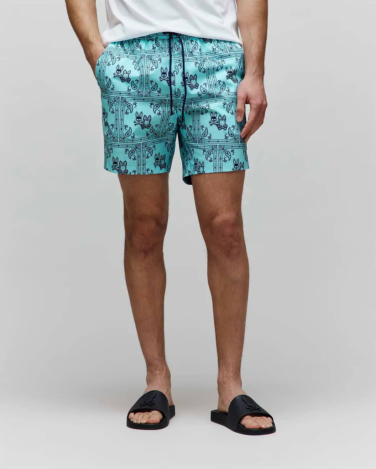 Mens Luke Swim Trunk in aqua, featuring a dark blue all-over bandana print with repeated Psycho Bunny skull logos and paisley details, crafted from smooth, quick-dry fabric for a classic fit.