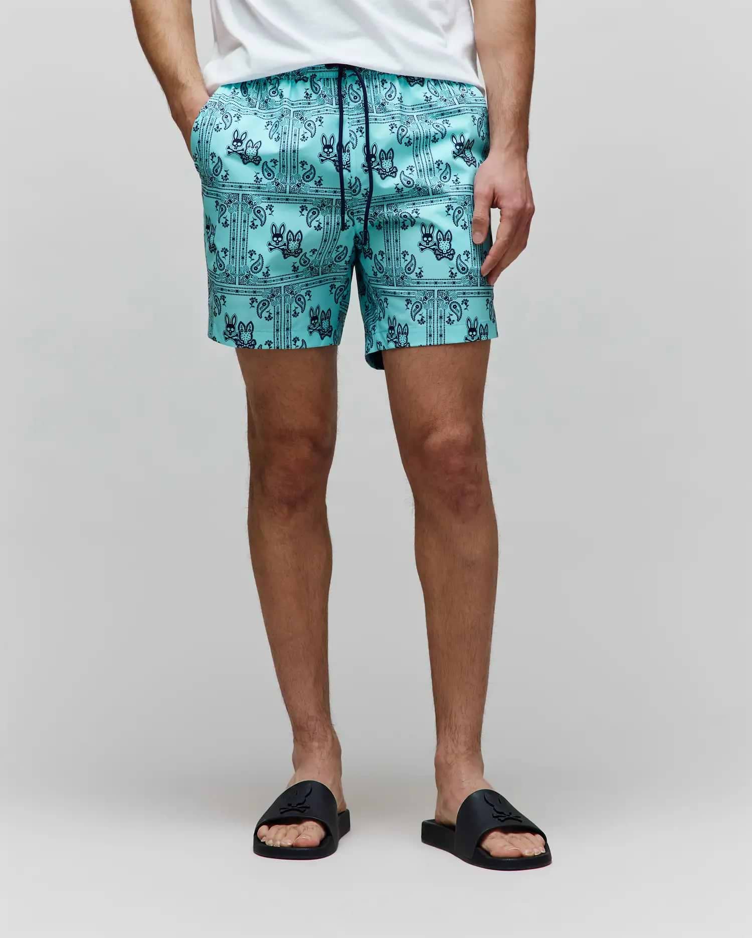 Mens Luke Swim Trunk in aqua, featuring a dark blue all-over bandana print with repeated Psycho Bunny skull logos and paisley details, crafted from smooth, quick-dry fabric for a classic fit.