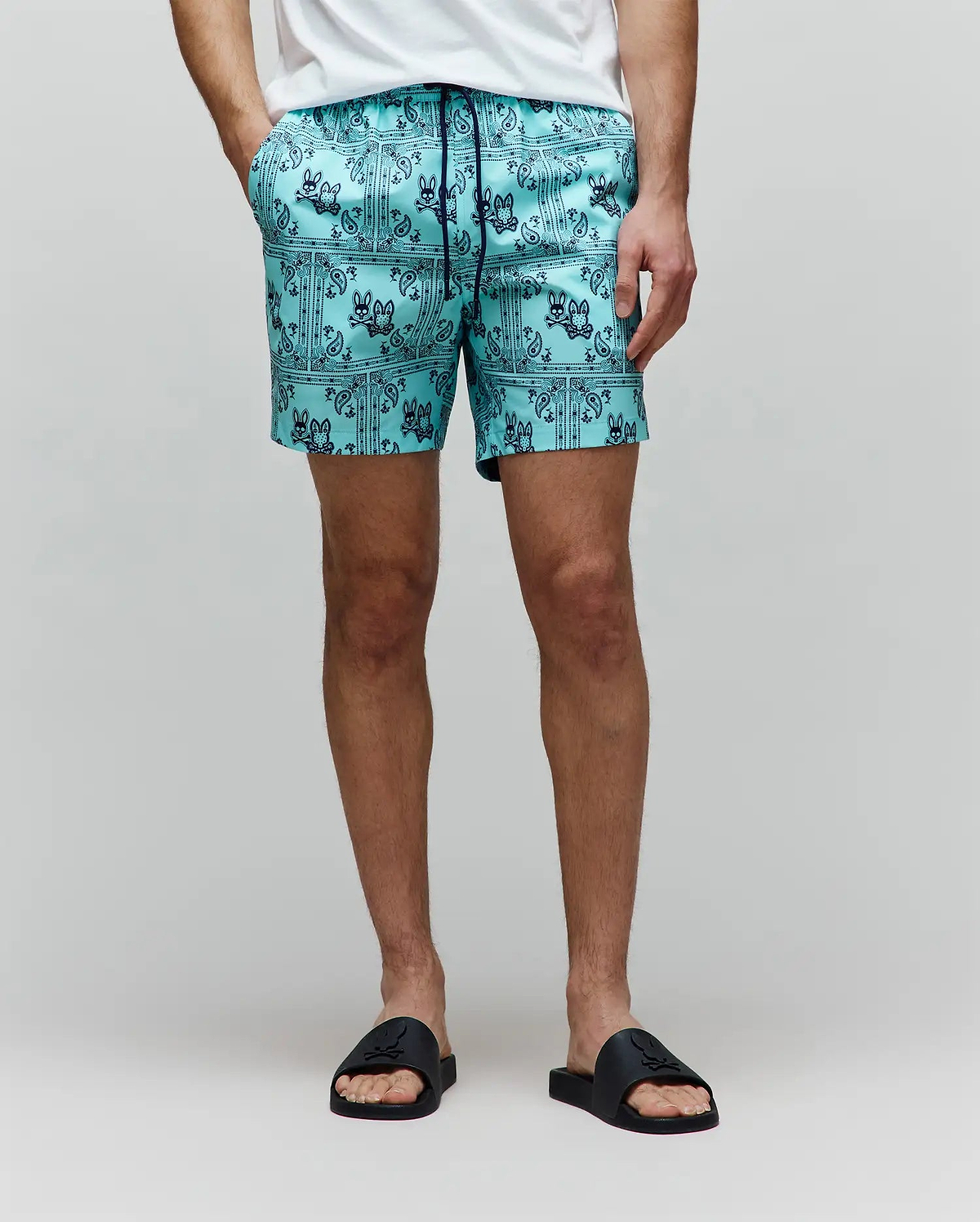 Mens Luke Swim Trunk in aqua, featuring a dark blue all-over bandana print with repeated Psycho Bunny skull logos and paisley details, crafted from smooth, quick-dry fabric for a classic fit.