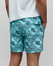 Mens Luke Swim Trunk in aqua with a dark blue all-over bandana paisley print featuring repeated Psycho Bunny skull logos, a classic fit, smooth quick-dry fabric, side pockets, and a back flap pocket.