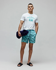 White classic fit jersey t-shirt with a large gradient blue Psycho Bunny text and bunny skull chest graphic. Mens Luke Swim Trunk in teal features an all-over dark blue bandana print with integrated bunny skull logos.