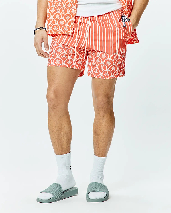 Mens Brad Swim Trunk, a coral orange classic fit swim trunk with white vertical stripes, a white palm tree and Psycho Bunny skull pattern border, and a small Psycho Bunny logo on the drawstring.