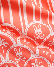 MENS BRAD SWIM TRUNK in vibrant coral with an all-over white print featuring vertical stripes, scalloped patterns, the iconic Psycho Bunny skull logo, and tropical palm trees on smooth fabric.