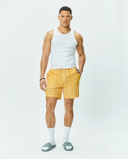 Mens Brad Swim Trunk, vibrant yellow with white vertical stripes on top, transitioning to an all-over Psycho Bunny skull logo pattern on the bottom, featuring a relaxed fit, smooth quick-dry fabric, and a white drawstring waist.