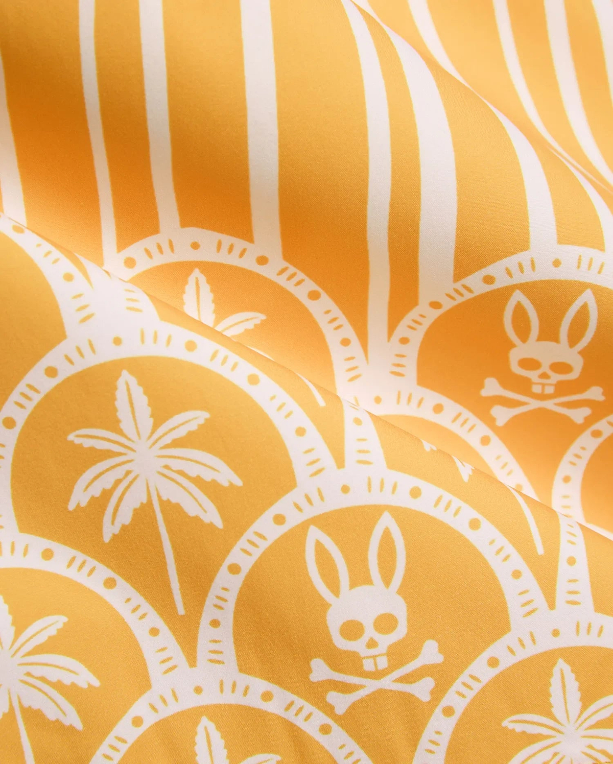 Vibrant yellow Mens Brad Swim Trunk with white vertical stripes, scalloped pattern, palm tree graphics, and repeated Psycho Bunny skull and crossbones logos on smooth quick-dry fabric.