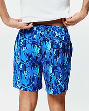 Mens Tanner Swim Trunk in a vibrant blue camouflage pattern, with repeated Psycho Bunny skull logos, an elastic waistband, back flap pocket, and a relaxed fit in smooth, quick-dry fabric.