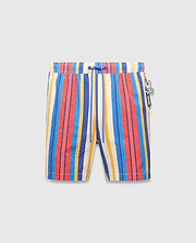 Mens Hubert Swim Trunk featuring vibrant multi-color vertical stripes in cream, blue, red, and yellow, with a textured fabric, royal blue drawstring, and a small Psycho Bunny skull logo charm on the right side.