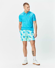 Bright blue pique polo with embroidered Psycho Bunny skull logo on chest, paired with Mens Ethan Swim Trunk 6 featuring a mint green and blue abstract pattern and drawstring waist. (4)