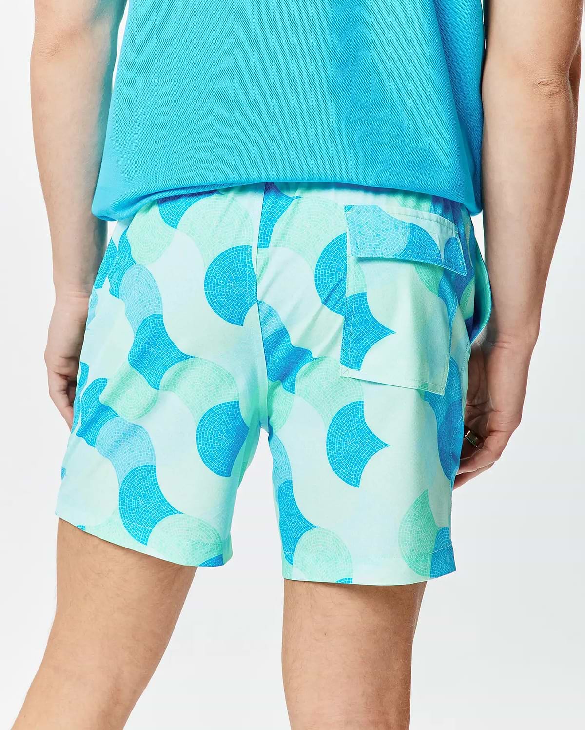 Mens Ethan Swim Trunk 6, a relaxed fit swim trunk in smooth fabric, featuring a vibrant light blue and mint green mosaic pattern with darker blue accents and a rear flap pocket. (2)