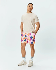 Mens Ethan Swim Trunk 6 with a multi-color abstract geometric pattern, featuring a black Psycho Bunny skull logo. Paired with a classic fit beige jersey tee with a white Psycho Bunny skull logo. (4)