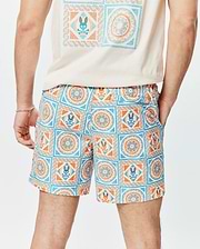 Mens Frank Swim Trunk 6, a classic fit, white swim trunk with a vibrant blue and orange mosaic tile pattern, featuring the iconic Psycho Bunny skull logo integrated throughout the print. Smooth fabric.