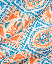 Mens Frank Swim Trunk 6, a smooth woven fabric with an off-white base, vibrant blue, orange, and peach mosaic-style all-over pattern featuring the iconic Psycho Bunny skull logo.