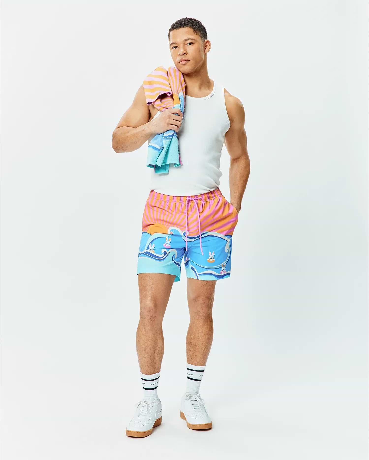 Mens Ray Swim Trunk 6 with a vibrant sunset stripe and ocean wave graphic featuring small Psycho Bunny skull logos, relaxed fit, quick-dry fabric, pink drawstring. (5)