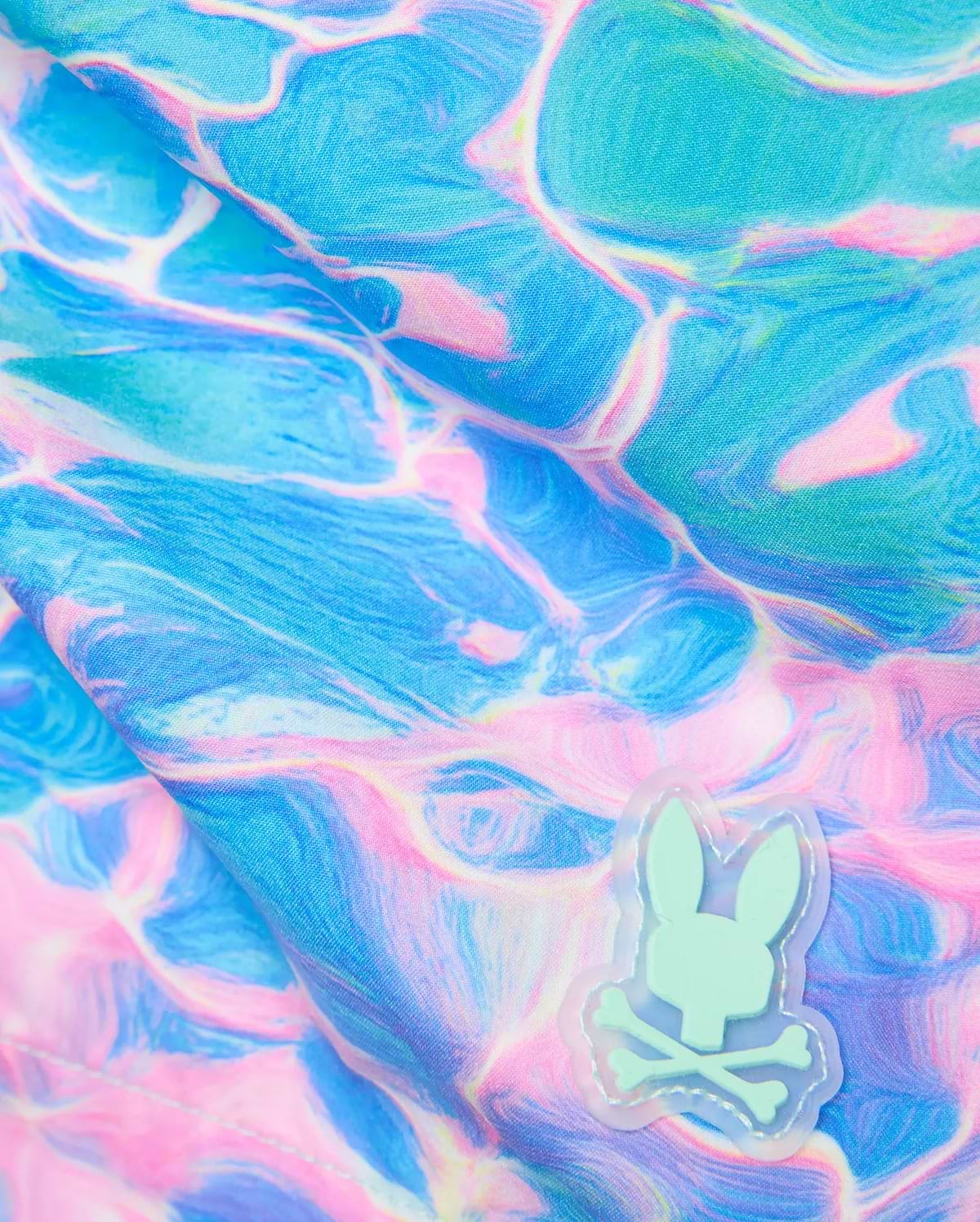 Mens Dayton Swim Trunk 6 featuring a vibrant blue and pink marbled water ripple pattern. A small, light mint green Psycho Bunny skull logo with an iridescent outline is stitched on. (6)