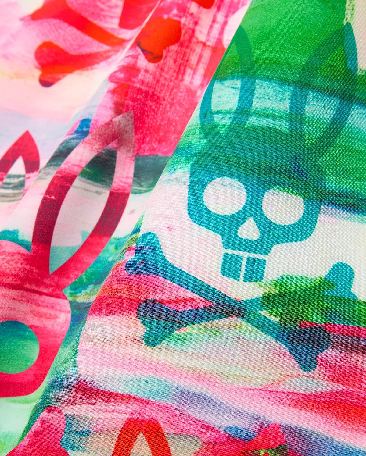 Mens Nate All Over Print Swim Trunk with a vibrant multi-color abstract brushstroke pattern in pink, red, green, and blue, featuring integrated Psycho Bunny skull and crossbones logos and bunny ear silhouettes.